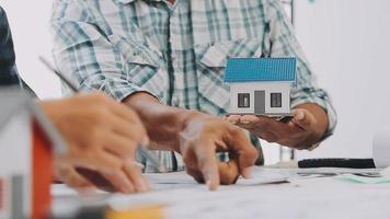 construcción y estructura concepto de ingeniero trabajando dibujo en Plano reunión para proyecto trabajando con compañero en modelo edificio y Ingenieria herramientas en trabajando sitio, construcción concepto video