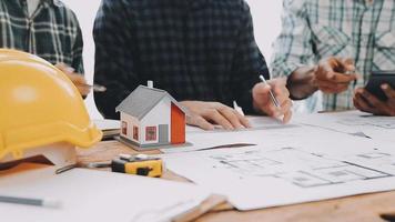 costruzione e struttura concetto di ingegnere Lavorando disegno su planimetria incontro per progetto Lavorando con compagno su modello edificio e ingegneria utensili nel Lavorando luogo, costruzione concetto video