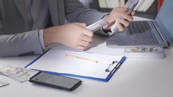 Male hand counts money and calculate with calculator. Businessman counts money in his office and makes a book of accounts with a calculator. video