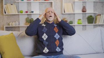 ziek oud Mens heeft een hoofdpijn. de oud Mens wrijven zijn hoofd heeft een hoofdpijn. video