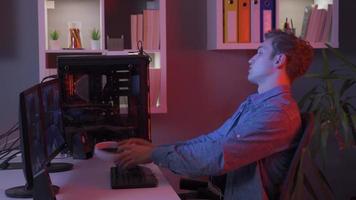 aggressiv, verlieren jung Mann spielen Video Spiel auf seine Computer. jung Mann spielen aufregend Spiel und spielen online Video Spiel mit Computer.