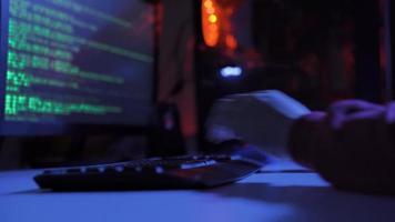 Masculin pirate Faire cyber attaque dans une foncé sombre pièce avec filtrer. pirate contourné la cyber-sécurité par dactylographie code sur clavier en retard à nuit. video