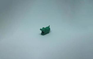pequeño barato y linda verde cocodrilo conformado cable mordedura objeto aislado en llanura blanco antecedentes. foto