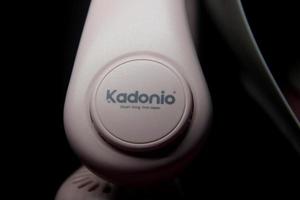 Jacarta, Indonesia - marzo 19, 2023 - rosado kadonio marca barato útil tecnología auriculares conformado cuello ventilador aislado foto en oscuro negro antecedentes.