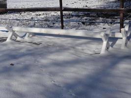 White obstacle bars - cavaletti covered with snow photo
