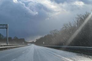 mojado autopista en contra un dramático cielo en un Tormentoso día foto