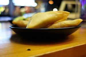 Samosas on a black plate as a close up photo