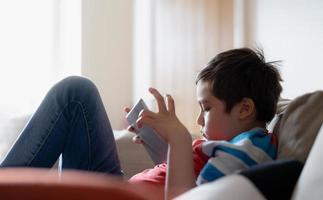 Education concept,School kid using tablet readying story from internet,Boy studying online learning at home,High key protrait Child holding digital pad using wifi playing game,Back to School photo