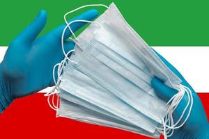 Doctor holds face masks in hands blue gloves on background national flag Islamic Republic of Iran. Concept quarantine, hygiene, pandemic outbreak. Surgical antibacterial face bandage photo