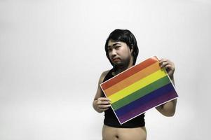 concepto del mes del orgullo lgbt, hombre guapo asiático maquillado y vestido con ropa de mujer, día de la libertad gay, retrato de no binario sobre fondo blanco foto