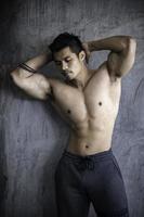 retrato de hombre asiático con gran músculo en el gimnasio, gente de tailandia, entrenamiento para una buena salud, entrenamiento de peso corporal, fitness en el concepto de gimnasio foto