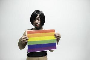 concepto del mes del orgullo lgbt, hombre guapo asiático maquillado y vestido con ropa de mujer, día de la libertad gay, retrato de no binario sobre fondo blanco foto