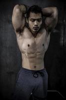 retrato de hombre asiático con gran músculo en el gimnasio, gente de tailandia, entrenamiento para una buena salud, entrenamiento de peso corporal, fitness en el concepto de gimnasio foto