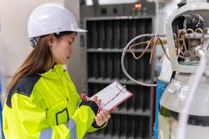 Asian engineer working at Operating hall,Thailand people wear helmet  work,He worked with diligence and patience,she checked the valve regulator at the hydrogen tank. photo