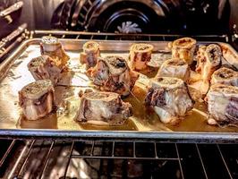 beef bone marrow pieces in the oven on a tray ready for a meal photo