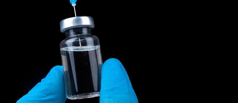 mano sosteniendo viola con vacuna contra el virus de la corona. foto