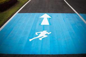 runner sign on road in park photo