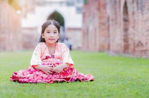 linda niña vistiendo Corea disfraces sentar en césped foto