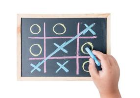 boy hand drawing a game of tic tac toe on a black chalkboard photo