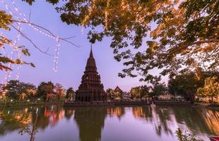 pagoda medio agua huay kaew templo en puesta de sol foto