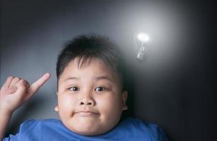 grasa chico obtiene brillante idea debajo brillante bulbo lámpara foto