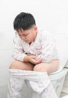 Fat boy sitting on the toilet. photo