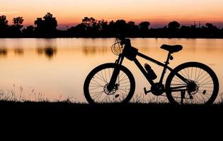 silueta bicicleta en puesta de sol antecedentes foto