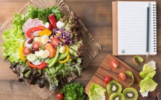 fresh mix vegetation salad on brown wood background photo