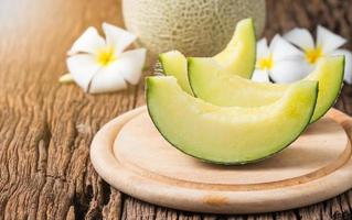 sliced japan melon on wood plate photo