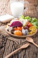 Mix fruits salad on wood plate with milk photo