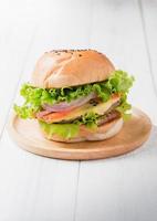Delicious hamburger on wood palte and wood background photo