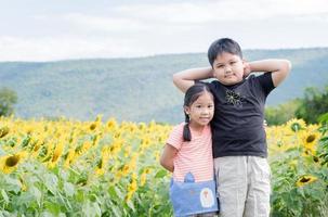 linda niña y chico abrazando divertido en girasol campo foto