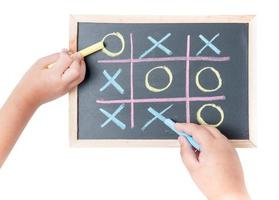 boy and girl hand drawing a game of tic tac toe photo