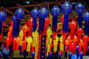 Closeup and look up view of decorated Thai Lanna style lanterns to hang on hotel lobby ceiling background with open lights on photo