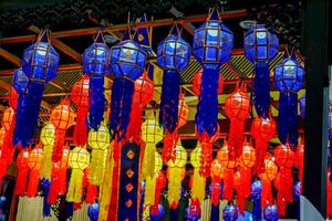 Closeup and look up view of decorated Thai Lanna style lanterns to hang on hotel lobby ceiling background with open lights on photo