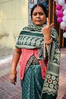 New Delhi, India - December 04 2022 - Unidentified people showing their ink-marked fingers after casting votes in front of polling booth of east Delhi area for MCD local body Elections 2022 photo