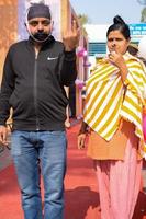 New Delhi, India - December 04 2022 - Unidentified people showing their ink-marked fingers after casting votes in front of polling booth of east Delhi area for MCD local body Elections 2022 photo
