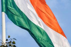 India flag flying high at Connaught Place with pride in blue sky, India flag fluttering, Indian Flag on Independence Day and Republic Day of India, tilt up shot, Waving Indian flag, Har Ghar Tiranga photo