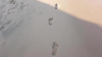 Close-up of human footprints in the wet sand at the seaside. Peace from the movement of sea water or waves. photo