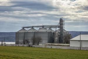 paisaje con moderno agrícola silo. conjunto de almacenamiento tanques cultivado agrícola cultivos Procesando planta. foto