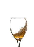 Classic glass and splashing liquid, isolated on a white background. Close photo