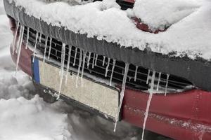 extremo invierno. coche en hielo. carámbanos en un coche de cerca. foto