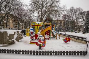 colorful children playground covered snow at the city park photo