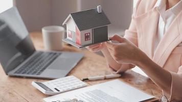 fastighetsmäklare presenterar och rådgör med kund till beslutsfattande teckna försäkringsformulär avtal, köp och sälj bostadsmodell, gällande bolåneerbjudande för och villaförsäkring video