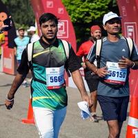 nueva delhi, india - 16 de octubre de 2022 - carrera de media maratón de vedanta delhi después de covid en la que los participantes del maratón están a punto de cruzar la línea de meta, media maratón de delhi 2022 foto