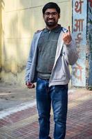 New Delhi, India - December 04 2022 - Unidentified people showing their ink-marked fingers after casting votes in front of polling booth of east Delhi area for MCD local body Elections 2022 photo