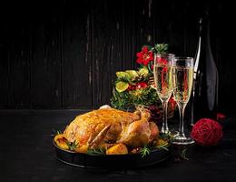 pavo o pollo al horno. la mesa navideña se sirve con un pavo, decorado con oropel brillante. pollo frito, mesa. cena de Navidad. foto