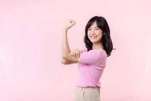 retrato joven asiático mujer orgulloso y confidente demostración fuerte músculo fuerza brazos flexionado posando, siente acerca de su éxito logro. mujer empoderamiento, igualdad, sano fuerza y valor concepto foto