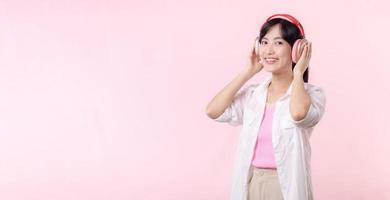 Smile pretty model person listen music song and enjoy dance with wireless headphone online audio radio sound. Positive fun exited joyful youth female woman sing on pink isolated background studio