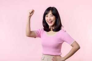 Portrait young asian woman proud and confident showing strong muscle strength arms flexed posing, feels about her success achievement. Women empowerment, equality, healthy strength and courage concept photo